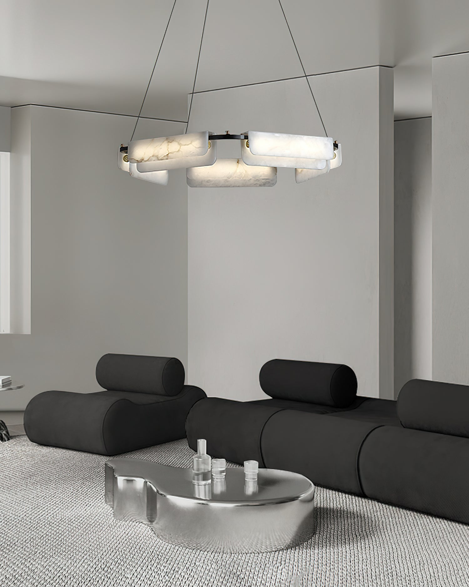 Clérachic Layered Alabaster Plate Chandelier over a black modular sofa and chrome table in a pale minimalist room.