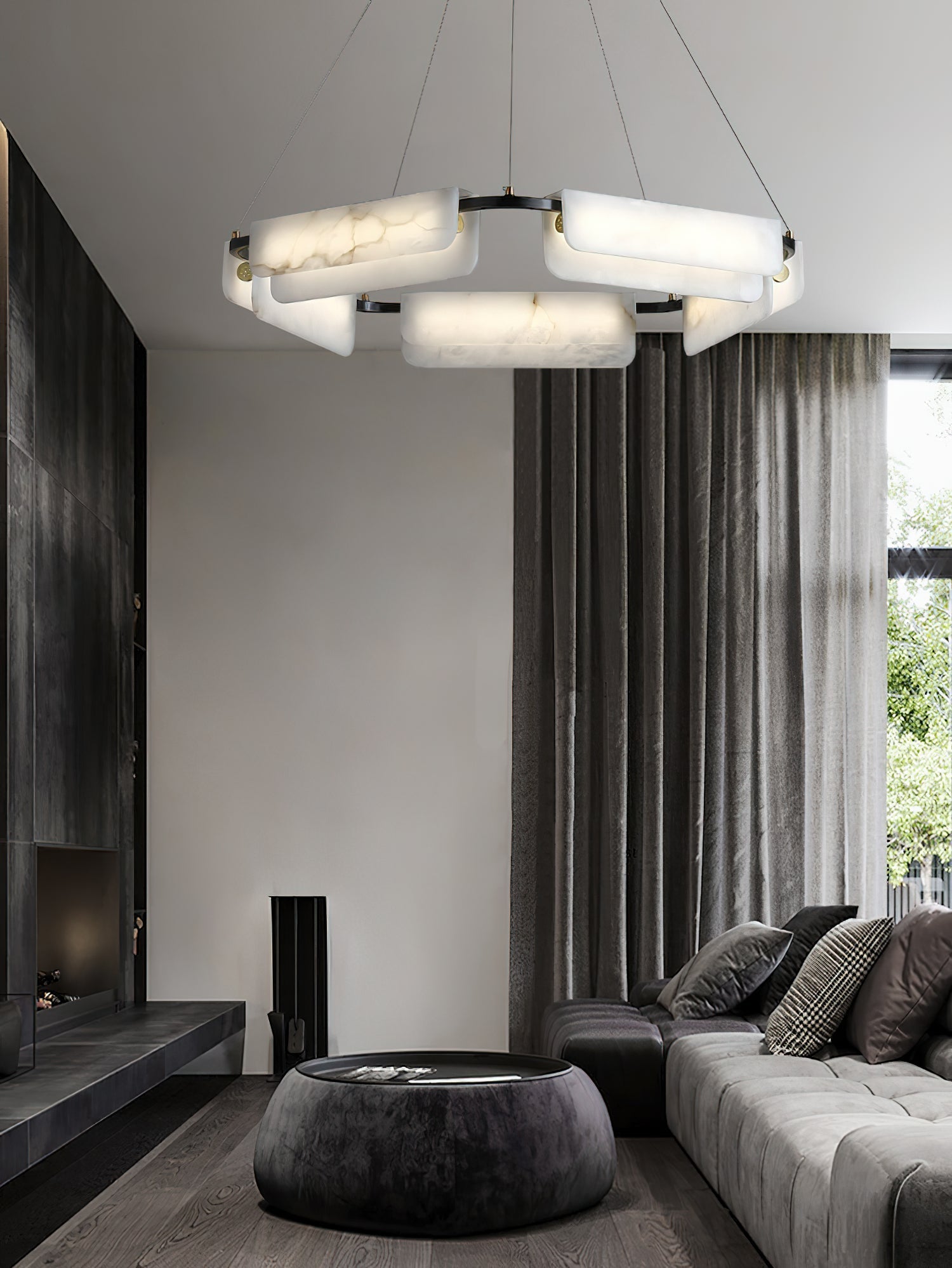 Clérachic Layered Alabaster Plate Chandelier lighting a fireplace lounge with a stone drum table and grey sofa.
