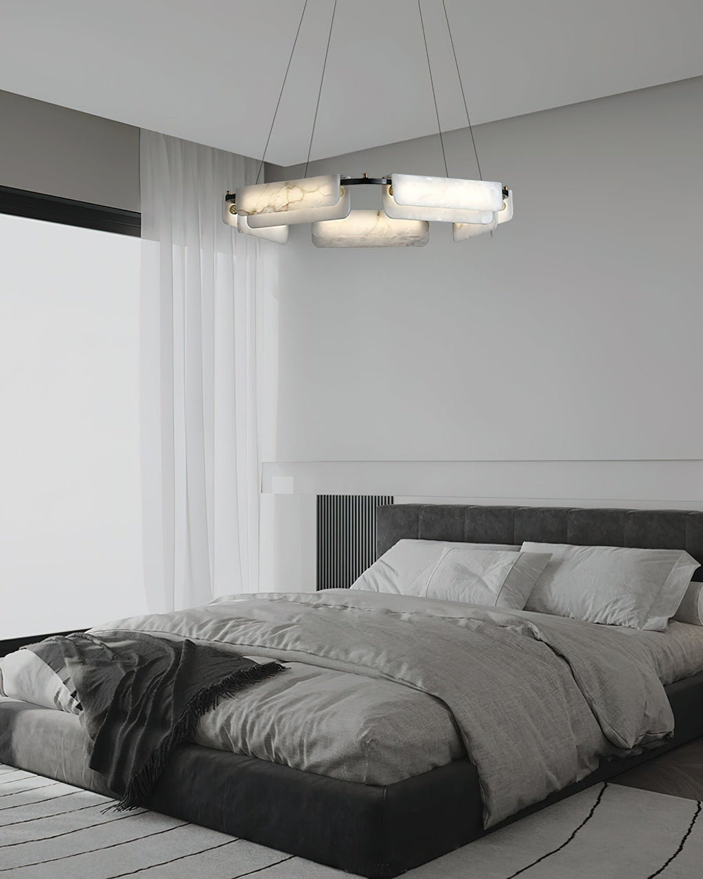 The Clérachic Layered Alabaster Plate Chandelier above a low black bed, soft light spilling across linen bedding.