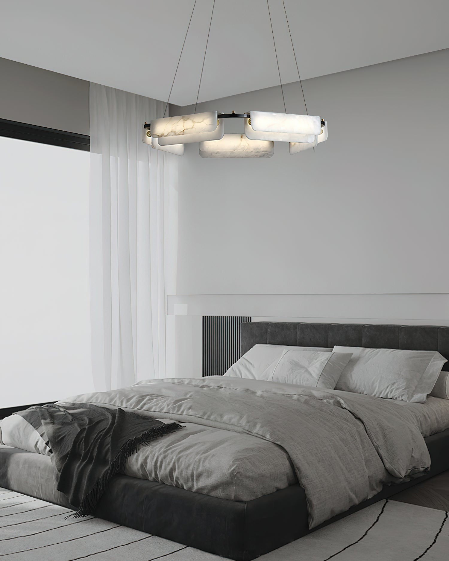 The Clérachic Layered Alabaster Plate Chandelier above a low black bed, soft light spilling across linen bedding.