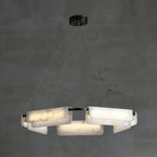 Clérachic Layered Alabaster Plate Chandelier lit against bare concrete, five cables running up to a black canopy.