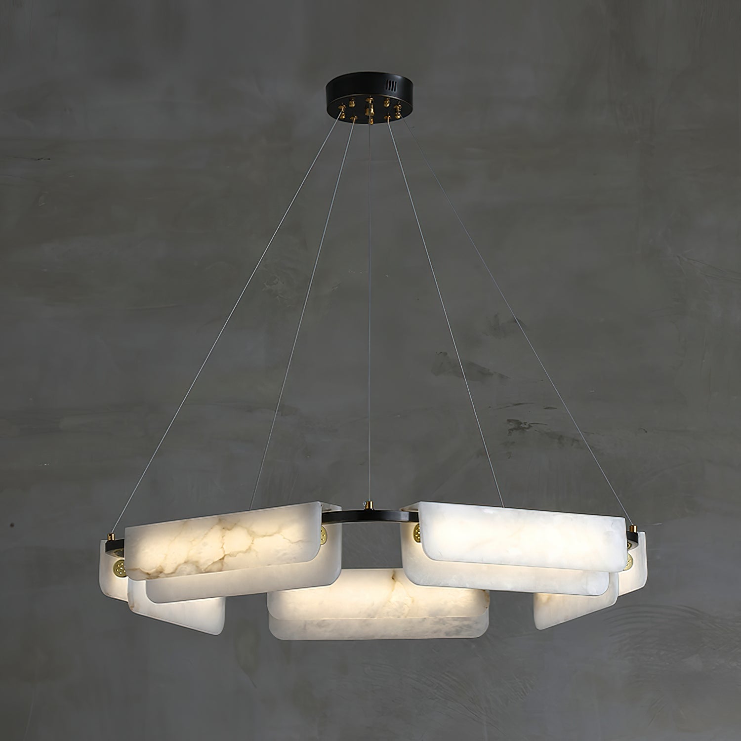 Clérachic Layered Alabaster Plate Chandelier lit against bare concrete, five cables running up to a black canopy.