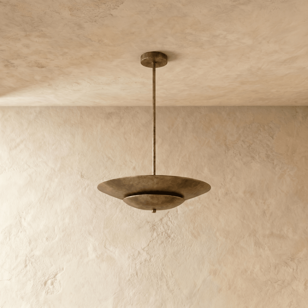 Clérachic pendant light in vintage brass viewed from another angle, the layered disc shade catching soft light.