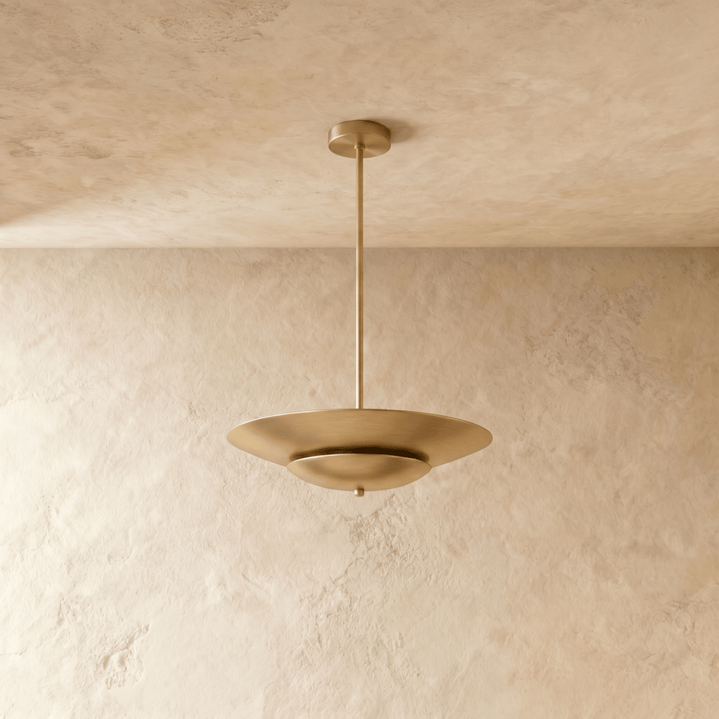 Clérachic pendant light in brushed brass shown close, highlighting the layered disc shade's smooth curve.