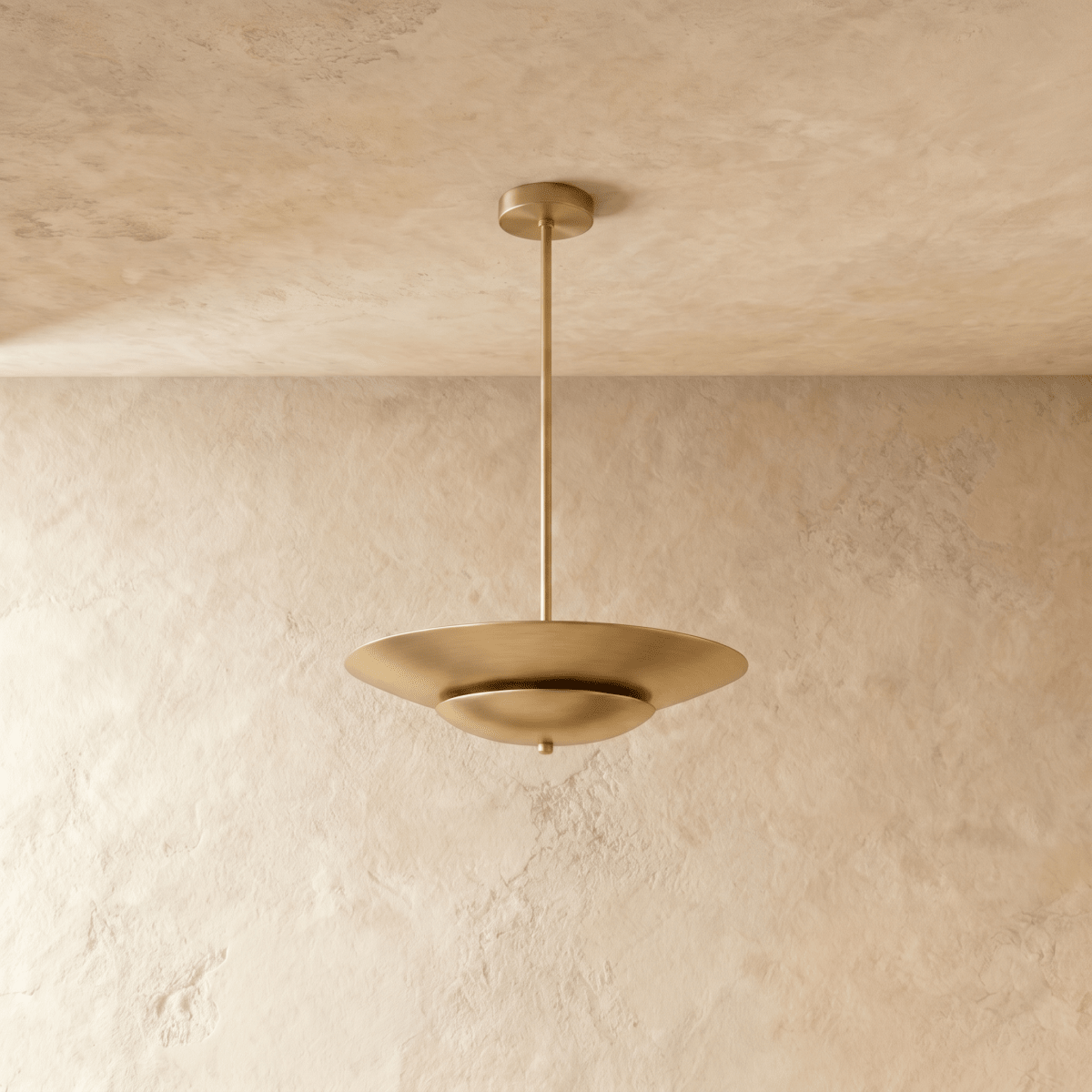 Clérachic pendant light in brushed brass shown close, highlighting the layered disc shade's smooth curve.
