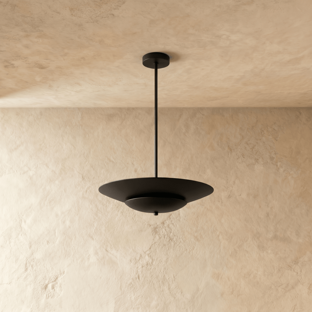 Clérachic pendant light in matte black shown close, the layered saucer shade's clean silhouette on display.