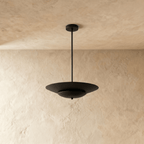Clérachic pendant light in matte black shown close, the layered saucer shade's clean silhouette on display.