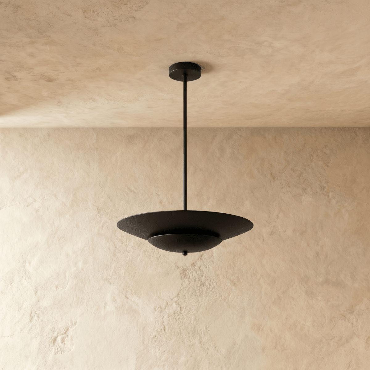 Clérachic pendant light in matte black shown close, the layered saucer shade's clean silhouette on display.