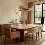 Clérachic pendant light in brushed brass hanging over a walnut dining table set for a sunlit family meal.