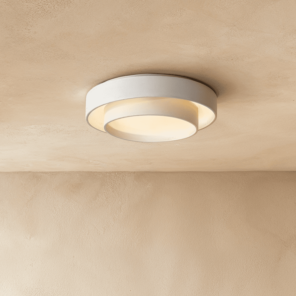 Clérachic white two-tier round ceiling light with a smaller drum inside a wider ring, glowing softly on a limewash ceiling.