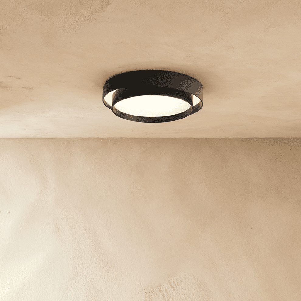 Clérachic black layered round flush ceiling light with a frosted lit centre, mounted on a plastered ceiling.