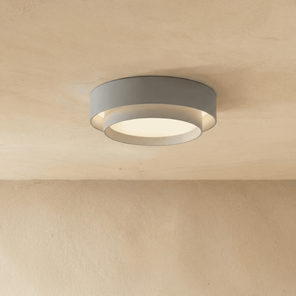 Clérachic grey two-tier round ceiling light with a white inner drum and soft central glow on a limewash ceiling.