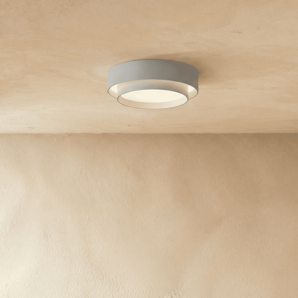 Clérachic grey layered round flush ceiling light with a pale inner ring, softly lit on a plastered ceiling.