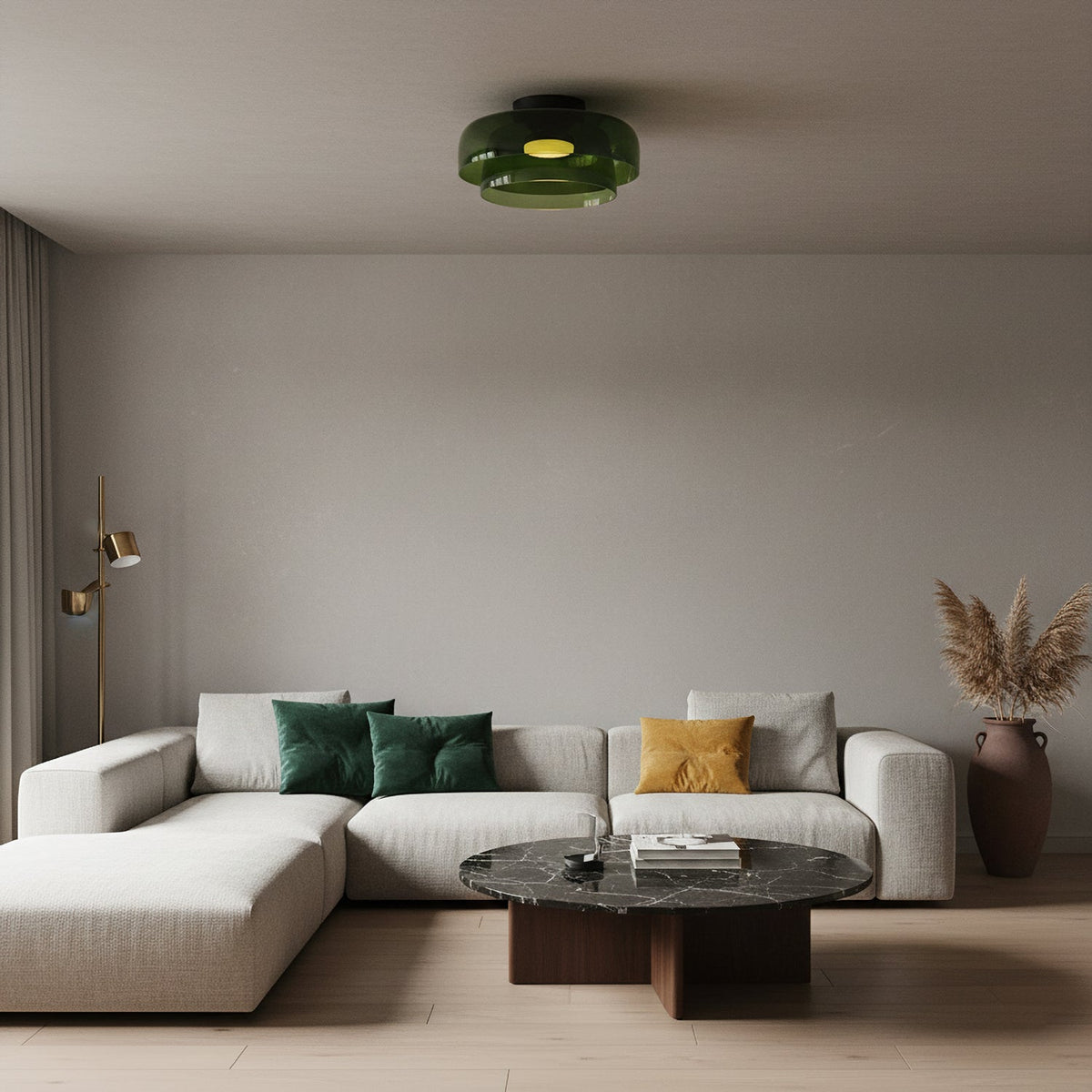A small green glass Clérachic ceiling light over a cream corner sofa and a dark marble coffee table.