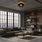 A Clérachic ceiling light with smoky dark glass above a loft living room with a brick wall and tall steel windows.