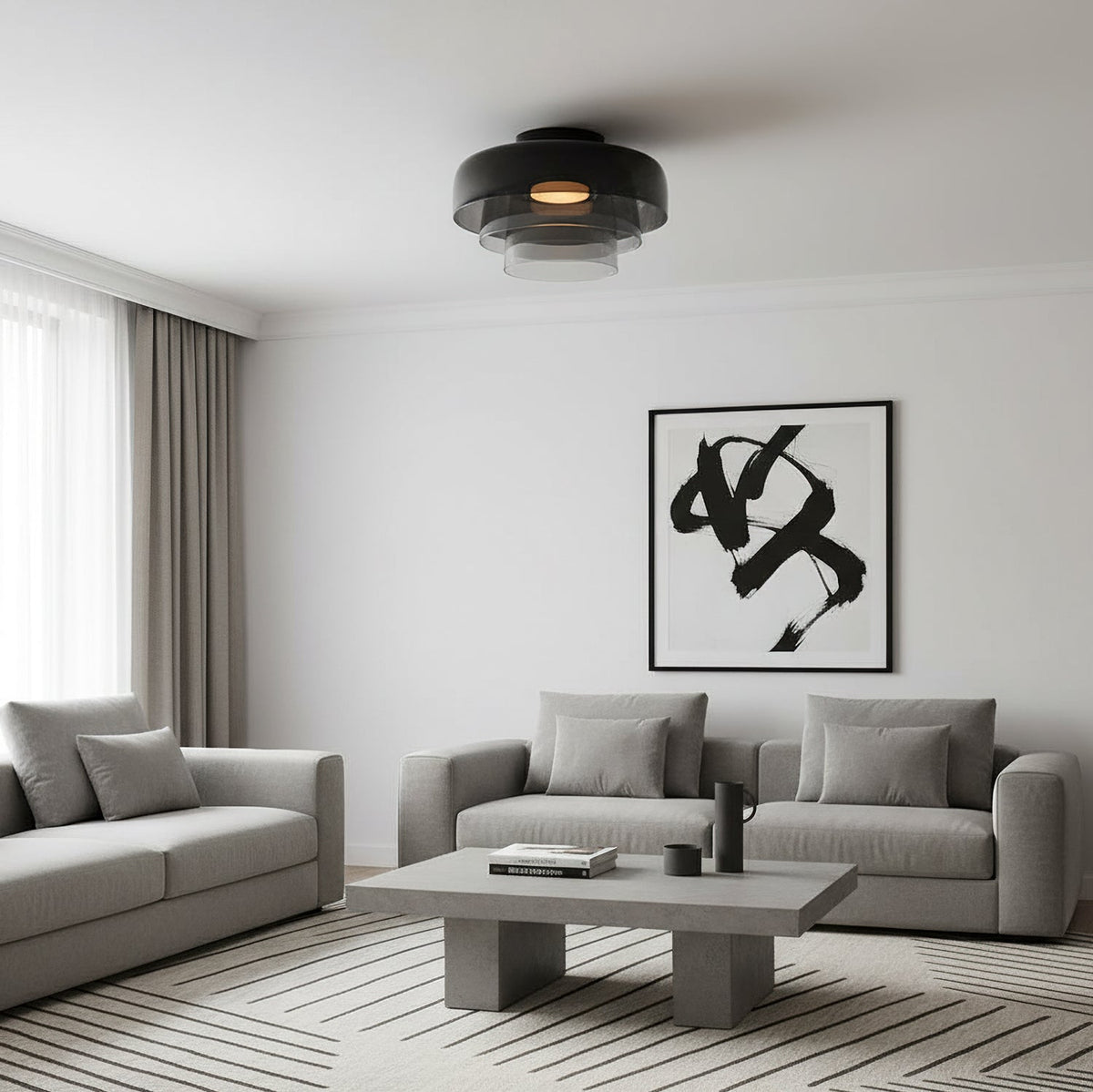 A smoky grey layered glass Clérachic ceiling light above a grey sofa and a concrete coffee table.