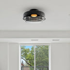 A smoky grey layered glass Clérachic ceiling light in a white room, with a window and trees behind it.