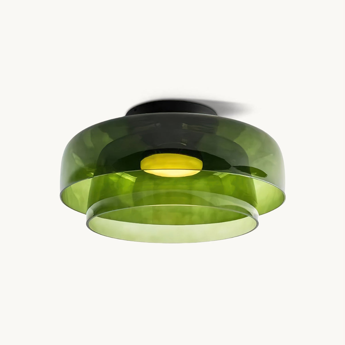 A layered green glass Clérachic ceiling light, lit, with a black canopy, cut out on a plain off-white backdrop.