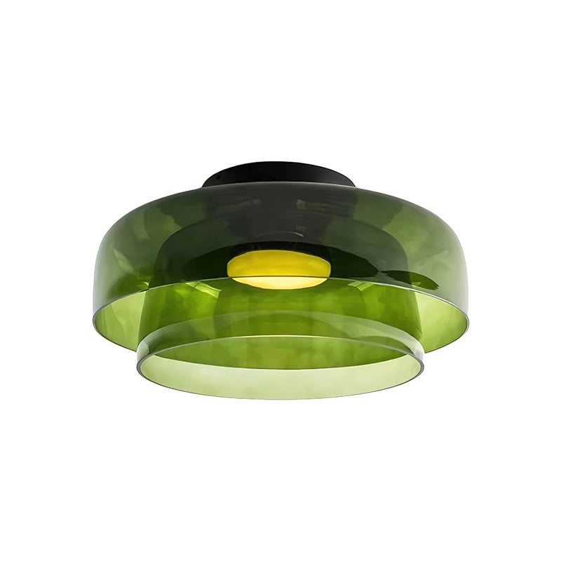 A green glass Clérachic ceiling light with a wide upper shade and a smaller lower layer, on a white backdrop.