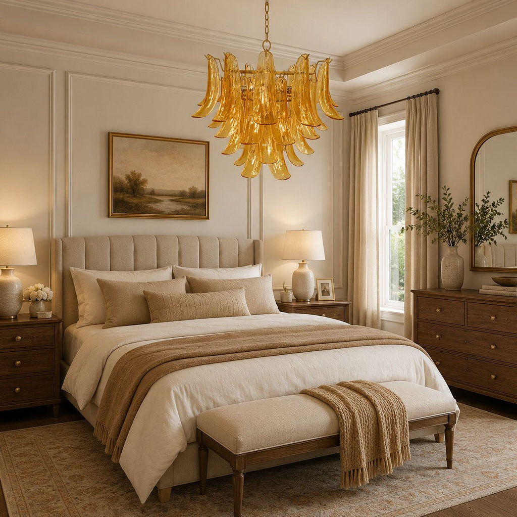Above a cream upholstered bed in a panelled bedroom, a Clérachic chandelier of golden amber glass leaves hangs from the ceiling.