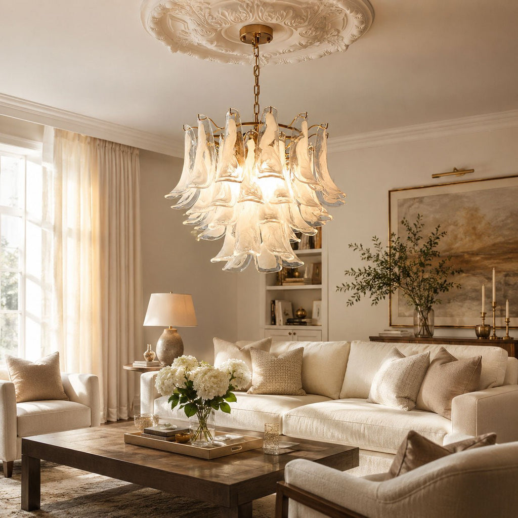 A frosted white glass leaf chandelier from Clérachic hangs from a ceiling rose over a cream sofa and a dark wood coffee table.