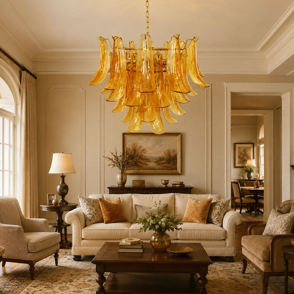 Clérachic chandelier of amber glass leaves hanging in a formal sitting room above a cream sofa and a dark coffee table.