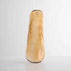 Close view of a single honey-amber glass leaf with a darker edge, upright on a soft grey background, from Clérachic.