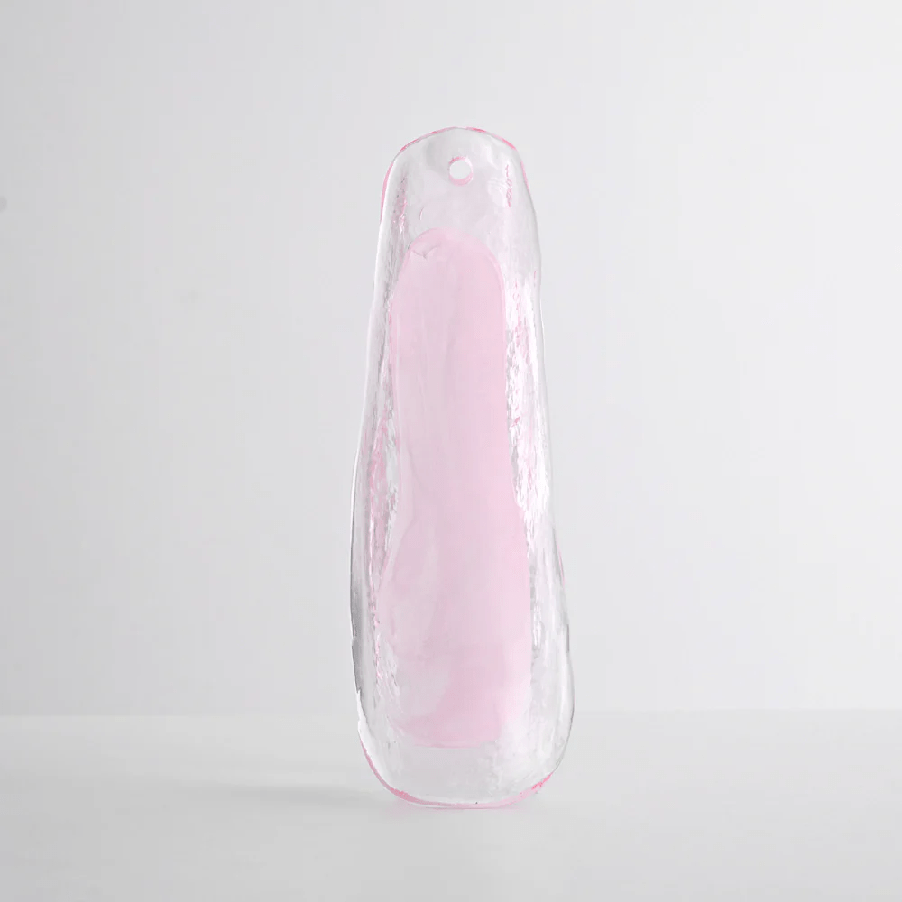 Single glass leaf in translucent pale pink with a clear rim, shown upright against a soft grey backdrop for this Clérachic chandelier.