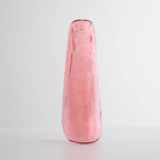 Rosy pink glass leaf with a rippled surface, standing on a pale grey surface, one of the glass options for this Clérachic chandelier.