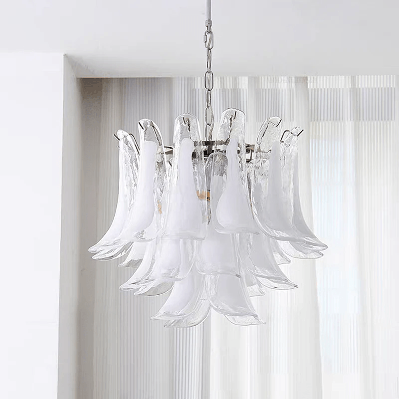 Clear and milky white glass leaves on this Clérachic chandelier, seen against a window with pleated sheer blinds.