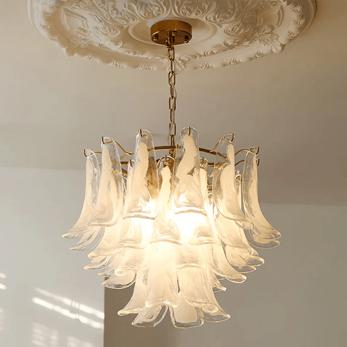 Frosted white glass leaf chandelier from Clérachic on a brass canopy, hung under a carved ceiling rose in a sunlit room.