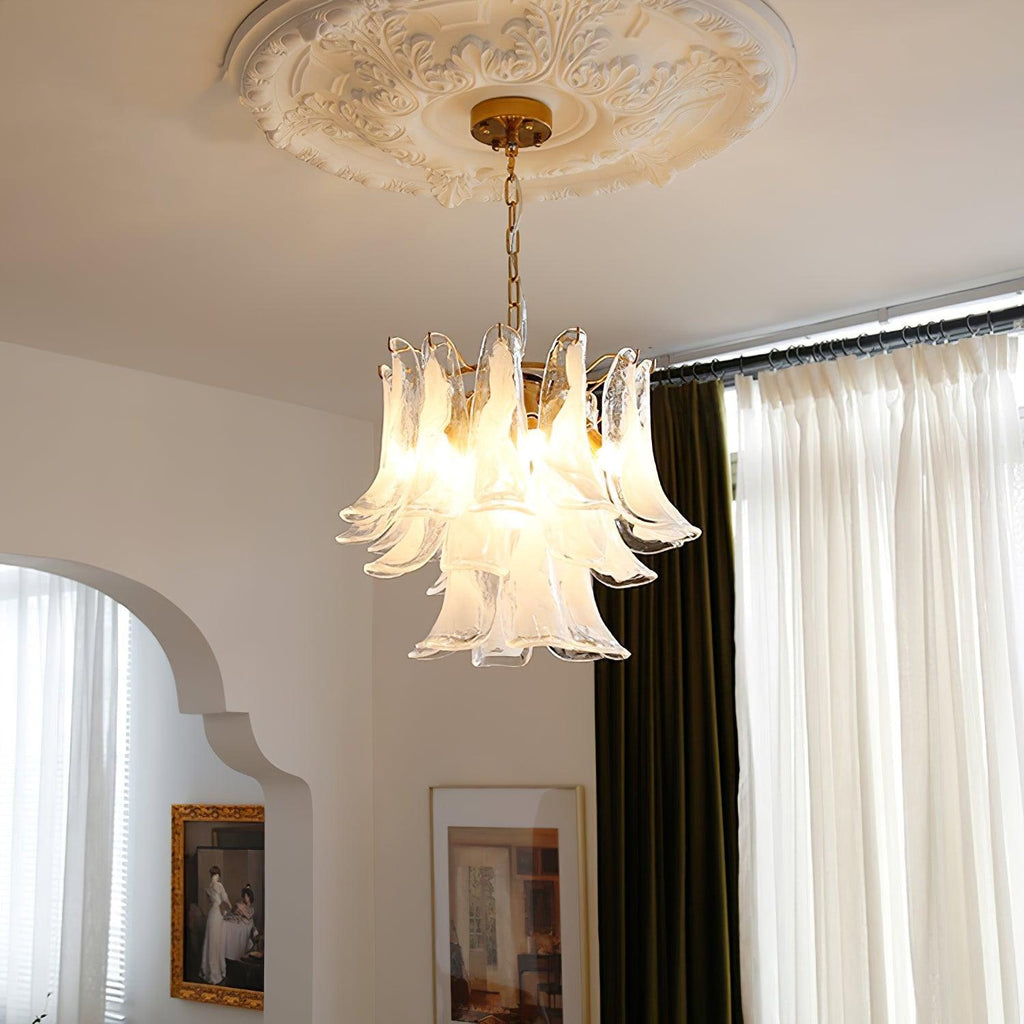 Soft glow from a white cloud glass leaf Clérachic chandelier, hanging under a plaster ceiling rose by an arched doorway.