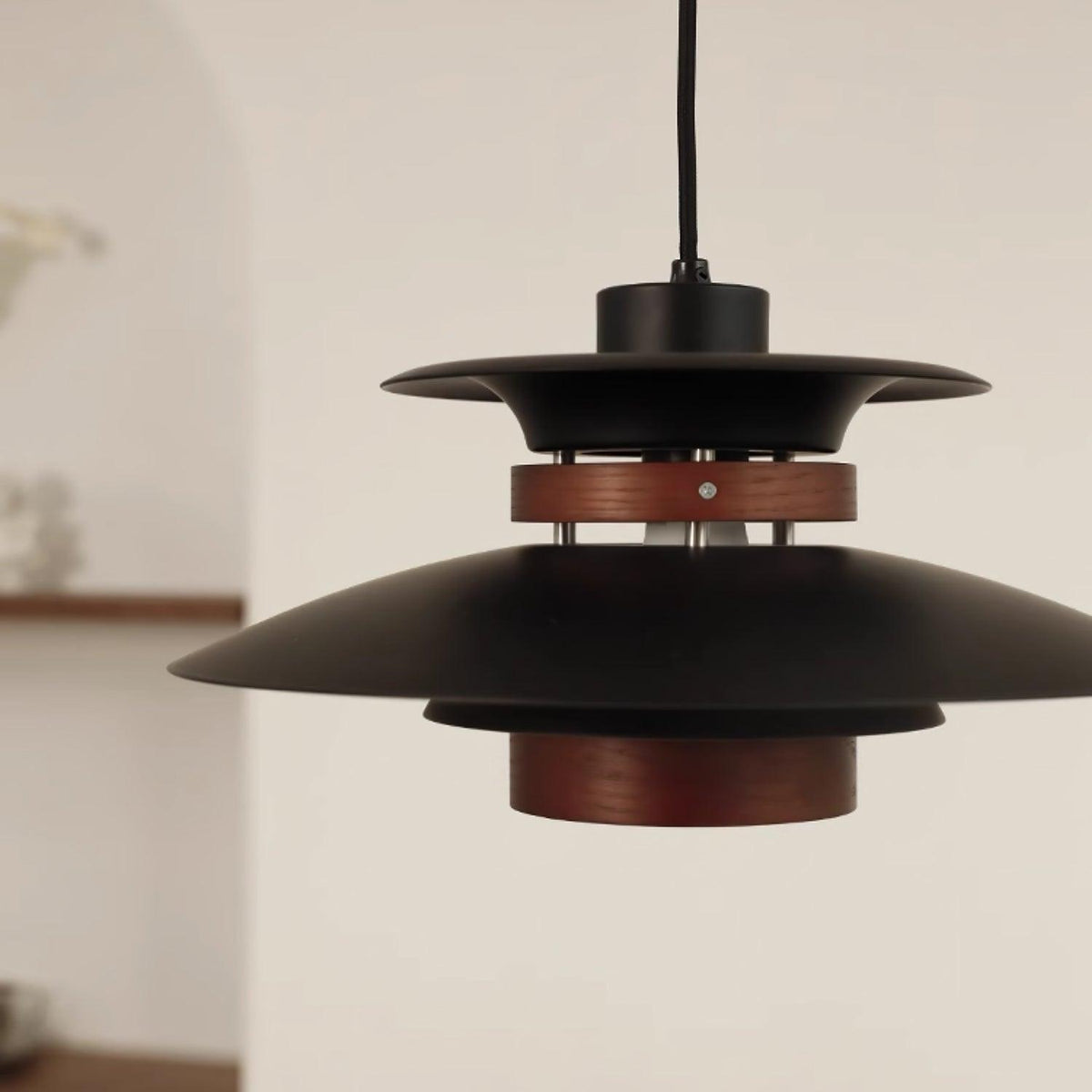 Close view of the black shades, the dark oak band and the wood lower cylinder on this Clérachic pendant.