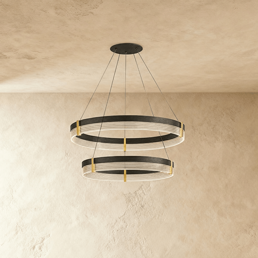 Two stacked rings on the Clérachic chandelier drop from a single ceiling plate, brass posts joining each acrylic band.