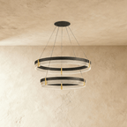 Two stacked rings on the Clérachic chandelier drop from a single ceiling plate, brass posts joining each acrylic band.