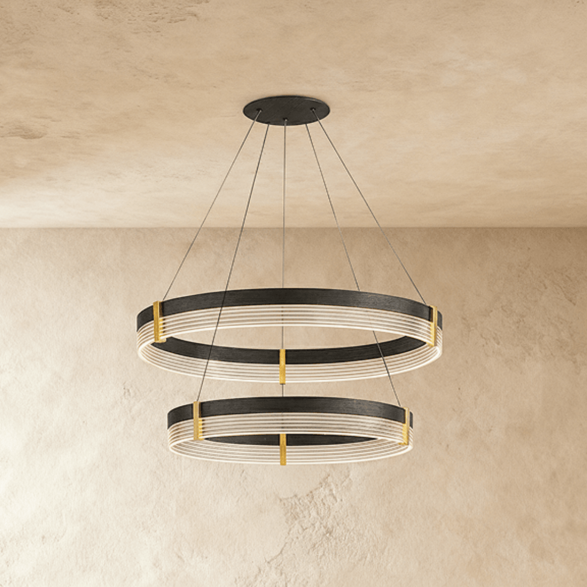 Angled view of the Clérachic two-tier ring chandelier shows both black bands glowing warmly against plaster walls.