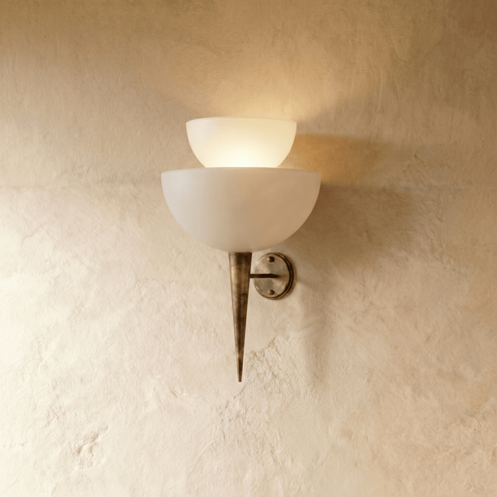 Clérachic wall lamp in vintage brass with two tiered frosted glass shades tapering to a slender pointed base.