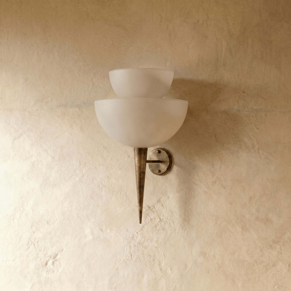 Clérachic wall lamp in vintage brass, front view of the stacked frosted glass shades on a plaster wall.