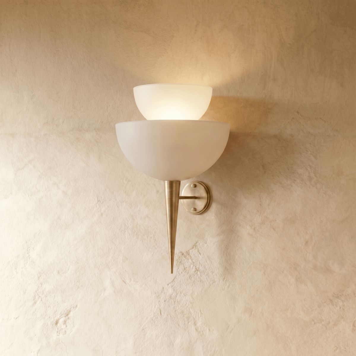 Clérachic wall lamp in a satin brass finish, tiered frosted glass shades above a slim pointed tip.