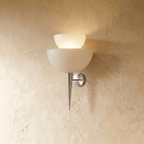 Clérachic wall lamp in chrome, two tiered frosted glass shades glowing above a slender pointed base.