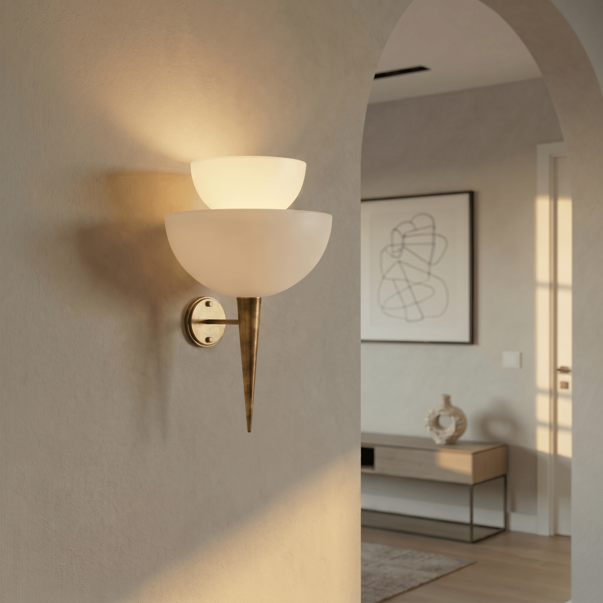 Clérachic wall lamp in brass lighting a plastered archway near a console table and abstract print.