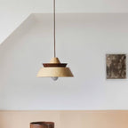 Clérachic layered wood pendant with a pale birch-toned shade and a dark walnut band, hung on a cord in a bright room.