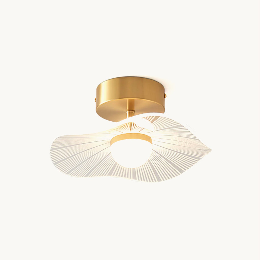 Brass-based ceiling light with a wavy clear acrylic shade, fine radiating lines and a round glowing bulb, on a white backdrop, from Clérachic.