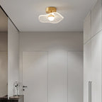 Brass flush ceiling light with a wavy ribbed shade lit in a white hallway with built-in wardrobes, a Clérachic ceiling light.