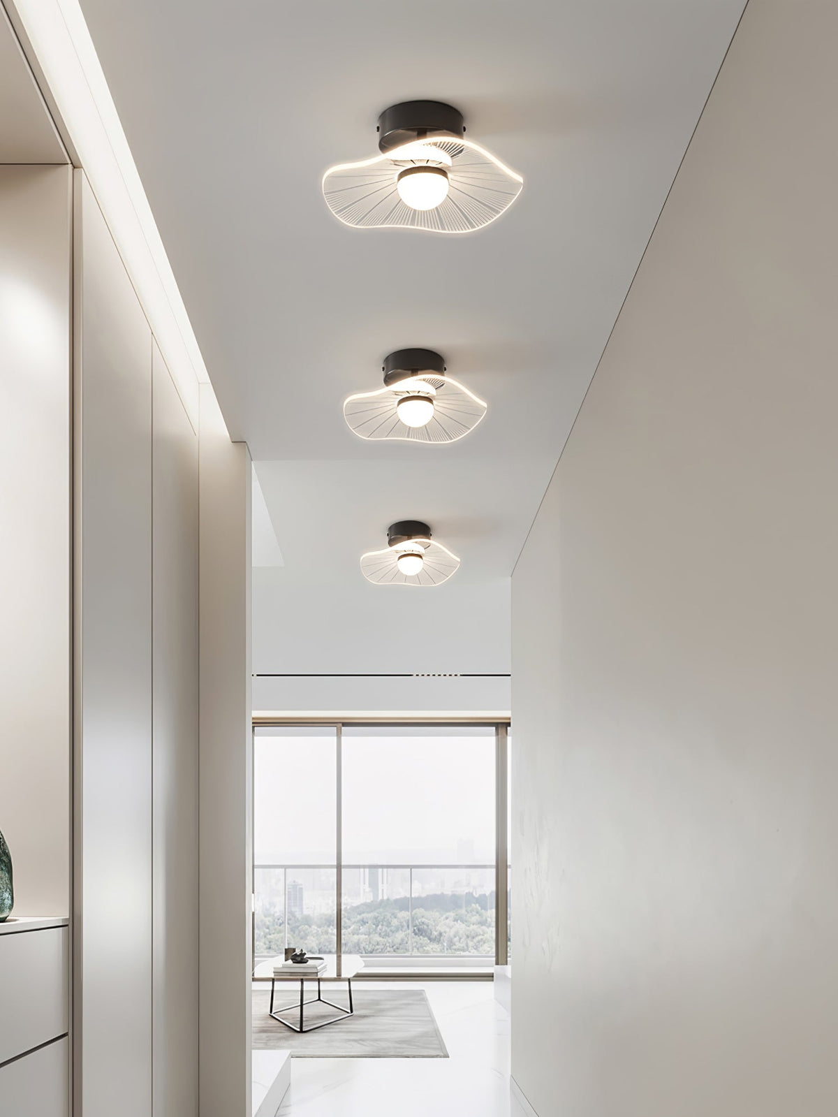 Three wavy acrylic ceiling lights in a row along a white hallway to a bright window, a Clérachic ceiling light.