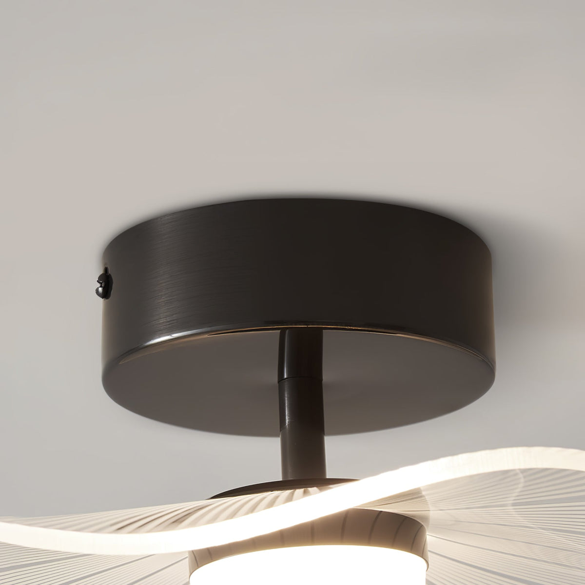 Close view of the black ceiling plate, short stem and the lower edge of the shade, on this Clérachic ceiling light.