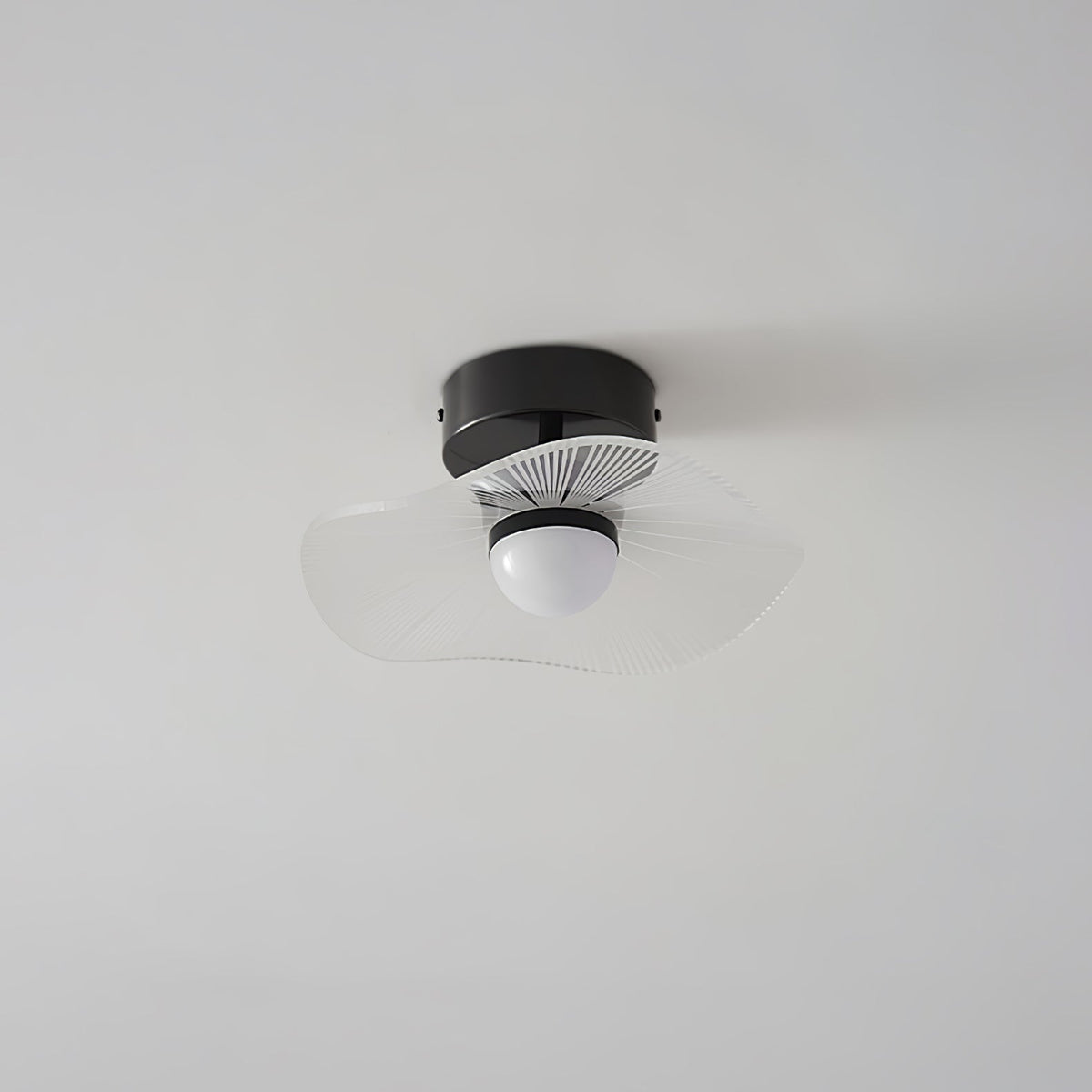 Black-fitted ceiling light with a pale, wavy, nearly clear shade and opal globe, on a grey ceiling, from Clérachic.