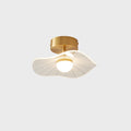 Brass-fitted ceiling light, front-on, with its ribbed wavy shade and warm glowing globe, on a pale grey ground, a Clérachic ceiling light.