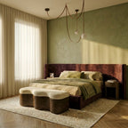 An unlit Clérachic leather and glass chandelier with two glass globes hangs above a bed in a sage green bedroom.