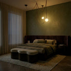 A lit Clérachic leather and glass chandelier glows softly with two globe shades above a bed in a dim green bedroom.
